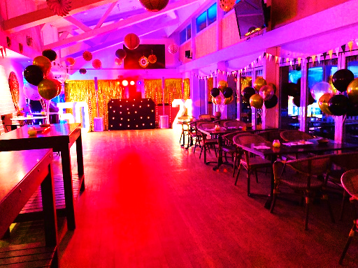 Party venue with pink lighting and tables
