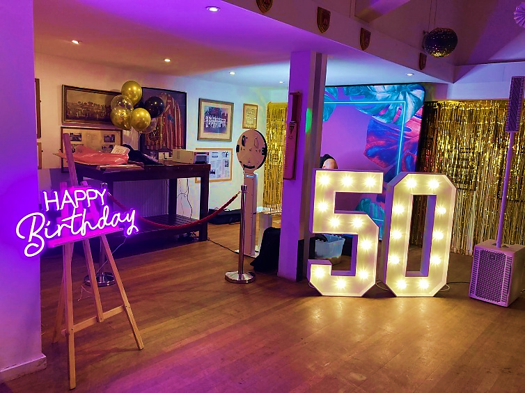 A 50th birthday display with illuminated numbers and party lighting