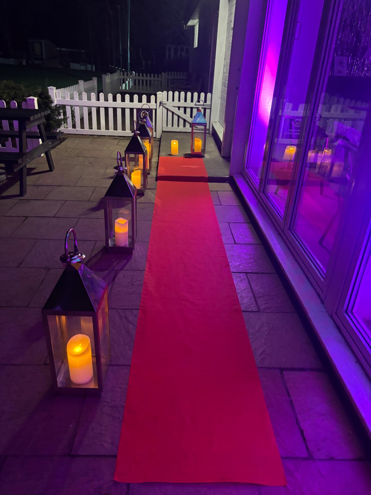 A lantern-lit red carpet outside the clubhouse