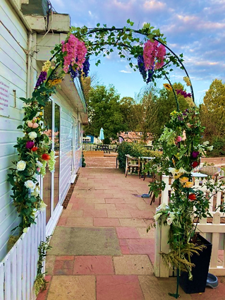 Flower-covered wedding arch on the clubhouse terrace