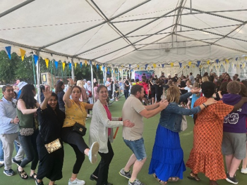 Guests dancing together beneath the event marquee