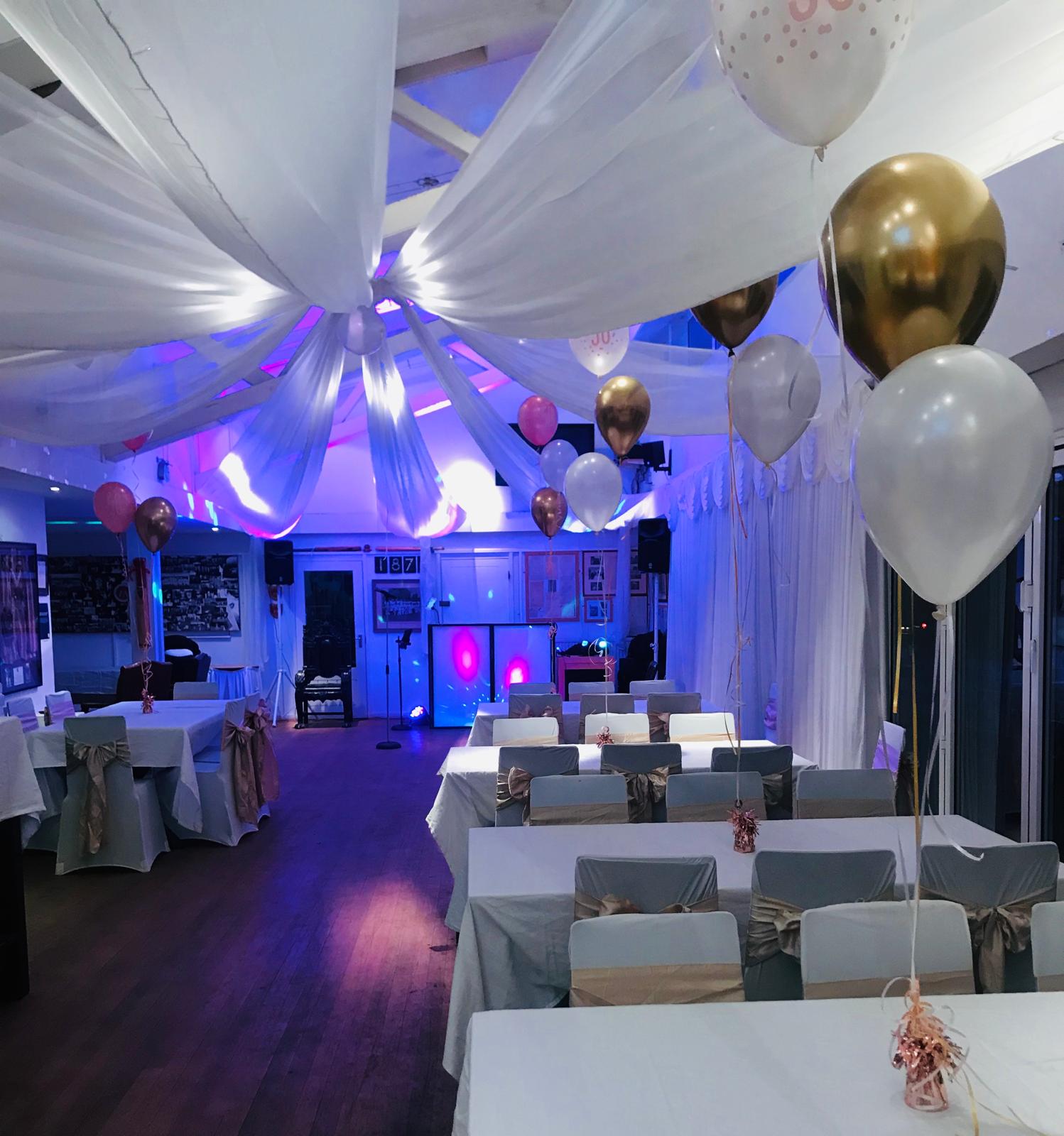 A 50th birthday party in the clubhouse with draped ceiling and banquet tables