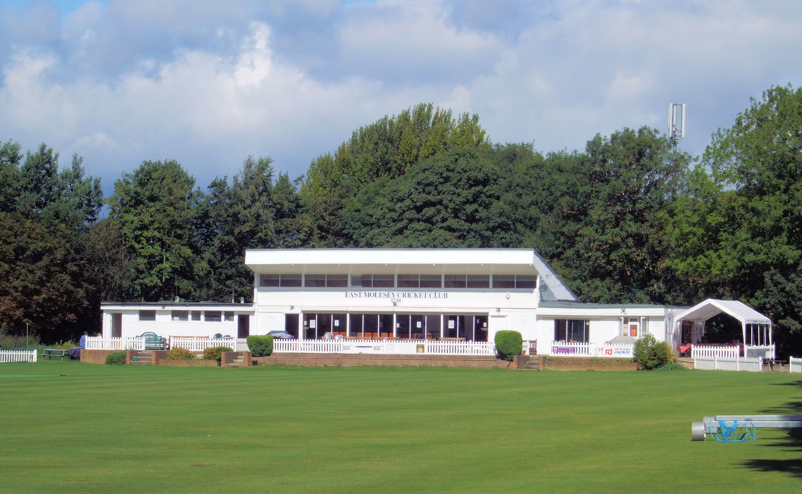 The East Molesey Cricket Club pavilion seen across the ground on a bright day
