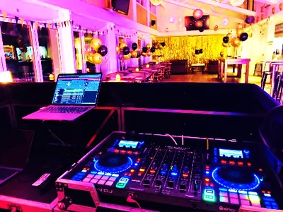 DJ booth set up with laptop and decks for an evening party