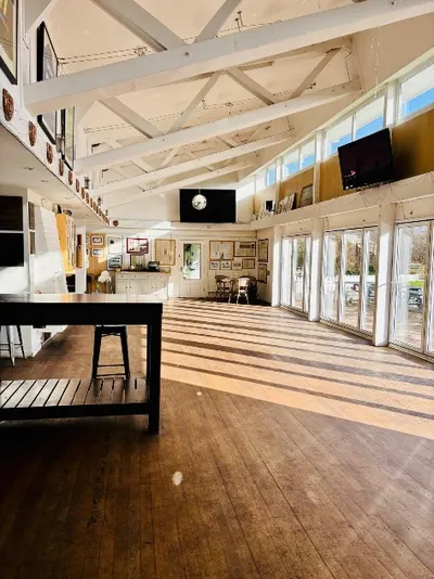 Bright, open clubhouse function room with wooden floors and large windows