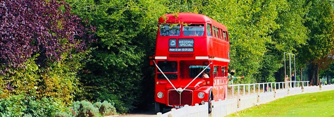 A red wedding bus arriving beside the cricket ground